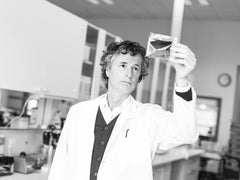 Scientist holding a chemical test up to the light in a laboratory